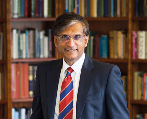 Professor Gerald Pillay sitting in front of a bookshelf in his office.